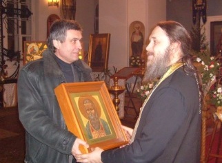 Михаил Смагин торжественно передает протоиерею Геннадию Беловолову икону святого праведного Иоанна Кронштадтского (10 января 2009 года)