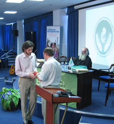 Сопредседатель Народного Собора Олег Кассин вручает президенту Фестиваля Сергею Чеснокову памятную медаль