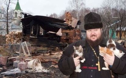 Иеромонах Серапион (Митько) стоит на фоне своего сгоревшего дома
