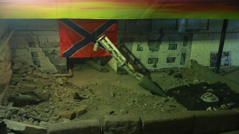 Головная часть реактивного снаряда :Град: с контейнером для поражающих элементов. Внизу слева трофей – флаг запрещенного на территории России ИГИЛ